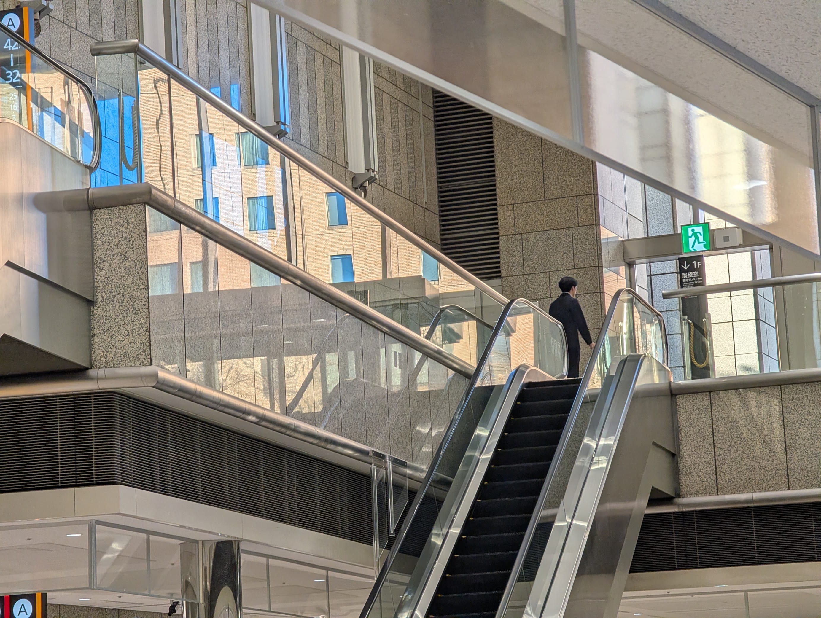 A glass handrail inside the Tokyo Metropolitan Government Building reflecting a bright fascade from outside