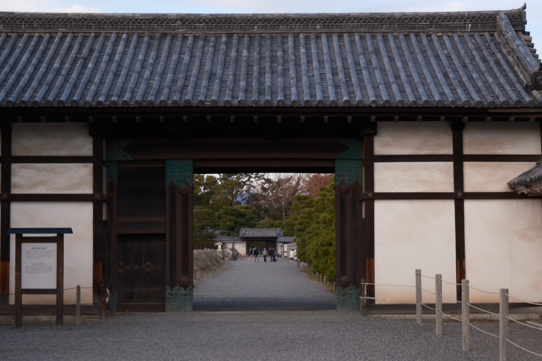 An large open wooden door framing a identical wooden door in the distant background taken in a flat perspective